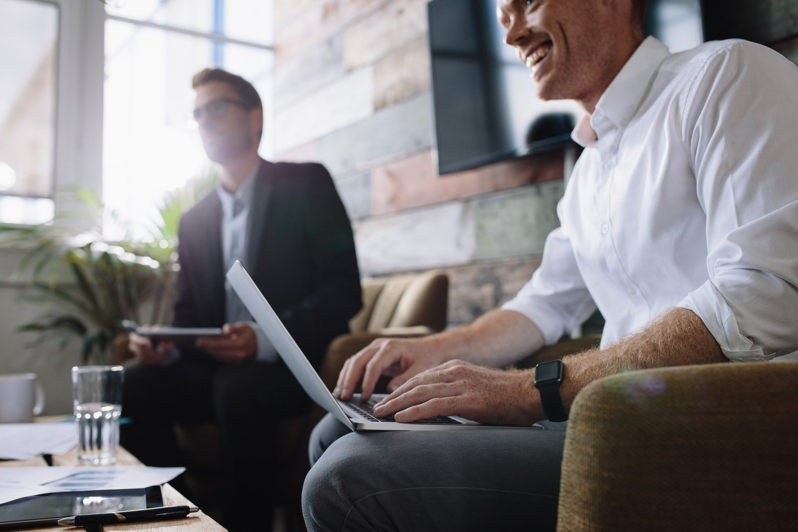 Businessman using laptop in meeting with corporate colleagues